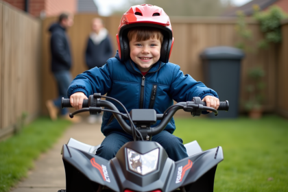 Garçon de 8 ans en casque rouge sur un quad sécurisé dans un jardin