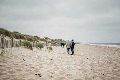 Promeneurs sur la plage de sable de La Panne avec vue sur les dunes de la côte belge